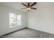 This bedroom has a ceiling fan, a window, and neutral gray carpeting at 12228 S Pewaukee St, Phoenix, AZ 85044
