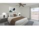 Bright bedroom featuring a ceiling fan, neutral decor and sliding glass door to the patio at 12228 S Pewaukee St, Phoenix, AZ 85044