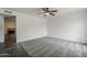 Spacious room featuring a ceiling fan, grey carpet, and a large window with great light at 12228 S Pewaukee St, Phoenix, AZ 85044