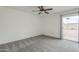Spacious bedroom features a ceiling fan, neutral carpet, and sliding glass door to the patio at 12228 S Pewaukee St, Phoenix, AZ 85044