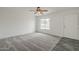 Spacious room featuring a ceiling fan, grey carpet, and a large window with great light at 12228 S Pewaukee St, Phoenix, AZ 85044