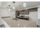 The bright kitchen boasts stainless appliances, a center island and stylish pendant lighting at 12228 S Pewaukee St, Phoenix, AZ 85044