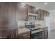 A kitchen with stainless steel appliances, dark cabinets, granite countertops and tile backsplash at 12228 S Pewaukee St, Phoenix, AZ 85044