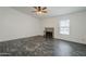 Living room with brick fireplace, large window, and plank flooring, ready for cozy nights at 12228 S Pewaukee St, Phoenix, AZ 85044