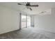 The carpeted living room features a ceiling fan and sliding glass door to the patio at 12228 S Pewaukee St, Phoenix, AZ 85044