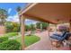 Inviting covered patio with pavers, lush landscaping, rocks, outdoor seating, and lounge chairs, perfect for relaxation and entertaining at 12686 N 95Th Way, Scottsdale, AZ 85260