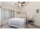 Cozy bedroom featuring a ceiling fan, plantation shutters, and a mirrored nightstand at 12686 N 95Th Way, Scottsdale, AZ 85260