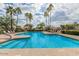 Sparkling community pool surrounded by palm trees, lounge chairs, and manicured landscaping under a partly cloudy sky at 12686 N 95Th Way, Scottsdale, AZ 85260