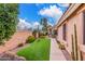 Side yard featuring desert landscaping, gravel, synthetic grass, cacti, and walkway; blending natural beauty with low maintenance at 12686 N 95Th Way, Scottsdale, AZ 85260