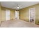 View of carpeted bedroom, with ceiling fan, open doors to closet and en suite bathroom at 131 N Higley Rd # 51, Mesa, AZ 85205