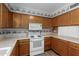 Traditional-style kitchen with wooden cabinets, white appliances, and neutral countertops at 131 N Higley Rd # 51, Mesa, AZ 85205