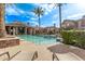 Relaxing view of a community pool surrounded by lounge chairs and palm trees on a sunny day at 14250 W Wigwam Blvd # 722, Litchfield Park, AZ 85340