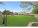 Spacious backyard features artificial turf, pool, mature trees, and a charming seating area, ideal for entertaining at 1444 E Myrna Ln, Tempe, AZ 85284