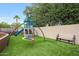 Backyard play area with climbing structure, swing set, trampoline, and artificial grass at 1444 E Myrna Ln, Tempe, AZ 85284