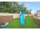 Backyard play area with a slide, climbing structure, swing set, and artificial grass at 1444 E Myrna Ln, Tempe, AZ 85284