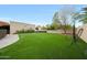 Expansive backyard features artificial turf, mature trees, and ample space for outdoor activities and entertainment at 1444 E Myrna Ln, Tempe, AZ 85284