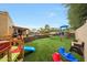 Backyard playground featuring artificial grass, play structures, swing set, and a bench at 1444 E Myrna Ln, Tempe, AZ 85284