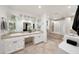 Well-lit bathroom featuring a double vanity with white cabinets and stylish fixtures, bathtub and shower at 1444 E Myrna Ln, Tempe, AZ 85284