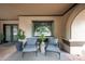 Covered front patio with gray chairs and greenery, tile floors, and neutral paint at 1444 E Myrna Ln, Tempe, AZ 85284