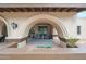 Inviting front porch featuring arched façade, comfortable seating, a grey rug and potted plants at 1444 E Myrna Ln, Tempe, AZ 85284