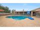 Backyard features a sparkling pool with a basketball hoop, patio seating, and a safety fence at 1444 E Myrna Ln, Tempe, AZ 85284