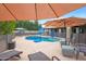 Inviting pool area featuring lounge chairs, umbrellas, and a sparkling pool, creating a perfect oasis for summer relaxation at 1444 E Myrna Ln, Tempe, AZ 85284