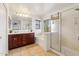 A bright bathroom with a tub, shower, large vanity, and tiled floors at 14744 W Poinsettia Dr, Surprise, AZ 85379