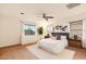 A serene bedroom with a plush bed, soft rug, ceiling fan, and large window with natural light at 14744 W Poinsettia Dr, Surprise, AZ 85379