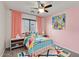 A colorful bedroom with a twin bed, bright bedding, artwork, and a window with natural light at 14744 W Poinsettia Dr, Surprise, AZ 85379