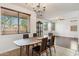 A dining room featuring a table with seating, a chandelier, and windows providing natural light to the space at 14744 W Poinsettia Dr, Surprise, AZ 85379
