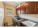 A laundry room with modern washer and dryer, storage cabinets, and a utility sink at 14744 W Poinsettia Dr, Surprise, AZ 85379