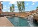 Full view of backyard featuring pool, waterfall feature, and patio with grill and outdoor seating at 14744 W Poinsettia Dr, Surprise, AZ 85379