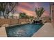 Backyard pool featuring a rock waterfall feature and lush landscaping at 14744 W Poinsettia Dr, Surprise, AZ 85379