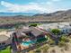 Beautiful aerial view of a home with a pristine pool and landscaped yard, situated with a desert mountain backdrop at 14841 S 6Th Pl, Phoenix, AZ 85048
