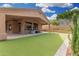 This covered patio and expansive artificial lawn creates a resort-like outdoor experience at 14841 S 6Th Pl, Phoenix, AZ 85048