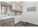 Bright laundry room featuring a sink, upper cabinets, and slate tile flooring at 14841 S 6Th Pl, Phoenix, AZ 85048