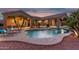 Stunning backyard pool with lush landscaping, lounge chairs, and a covered patio area at 14841 S 6Th Pl, Phoenix, AZ 85048