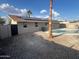 View of backyard with in-ground pool, rock landscaping, and solar panels on the roof at 1545 W Marco Polo Rd, Phoenix, AZ 85027