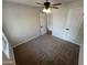 Bright bedroom featuring neutral carpet, a ceiling fan, and two white doors at 1545 W Marco Polo Rd, Phoenix, AZ 85027