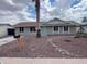 Single-story home with rock landscaping, large windows, and a light-blue front door at 1545 W Marco Polo Rd, Phoenix, AZ 85027