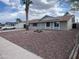 Single-story home with rock landscaping, large windows, and a light-blue front door at 1545 W Marco Polo Rd, Phoenix, AZ 85027