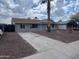 Single-story home with rock landscaping, large driveway, and a light-blue front door at 1545 W Marco Polo Rd, Phoenix, AZ 85027