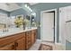 Well-lit bathroom featuring double sinks, wood cabinets, a large mirror, and a separate shower at 16139 S 178Th Dr, Goodyear, AZ 85338