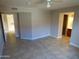 Spacious bedroom with a ceiling fan, tile floors, neutral paint, and access to the bathroom and hallway at 16602 N 25Th St # 129, Phoenix, AZ 85032