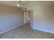 Bright bedroom with a ceiling fan, tile floors, neutral paint, and a door to the hallway at 16602 N 25Th St # 129, Phoenix, AZ 85032