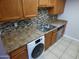 Efficient kitchen layout with dishwasher, stainless steel sink, and stone-look countertop at 16602 N 25Th St # 129, Phoenix, AZ 85032