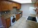 Updated kitchen with stainless steel appliances, modern backsplash, and in-unit laundry at 16602 N 25Th St # 129, Phoenix, AZ 85032