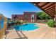 Community pool with clear blue water surrounded by fence and concrete patio at 16602 N 25Th St # 129, Phoenix, AZ 85032