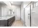 Bright bathroom featuring a walk-in shower and double vanity at 16679 W Saguaro Park Ln, Surprise, AZ 85387