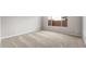 Empty bedroom with a beige carpet, white walls, and a window at 16679 W Saguaro Park Ln, Surprise, AZ 85387